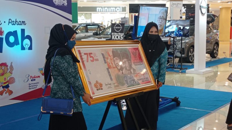 Pengunjung Palu Grand Mall berfoto bersama replika uang kertas ukuran besar pecahan Rp 75 ribu, Sabtu (12/2/2022)/hariansulteng