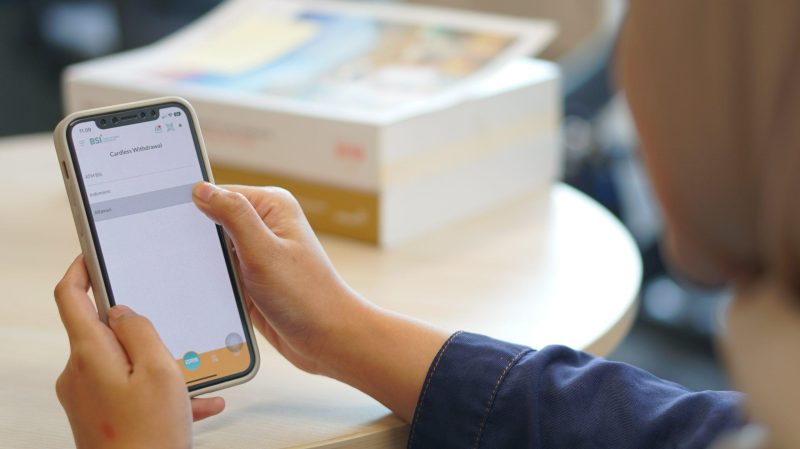 Nasabah sedang membuka aplikasi BSI Mobile untuk melakukan transaksi tarik tunai tanpa kartu melalui Alfamart. Fitur ini adalah hasil kerja sama antara BSI  dan Alfamart dalam menjawab kebutuhan nasabah untuk tarik tunai melalui e-banking/istimewa