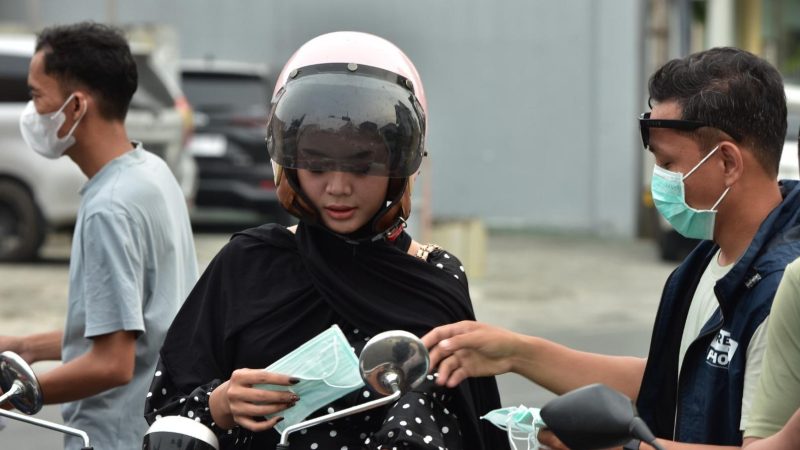 Pewarta Foto Indonesia (PFI) Kota Palu membagikan masker kepada sejumlah pengendara, Jumat (16/10/2026). (Foto: Istimewa)